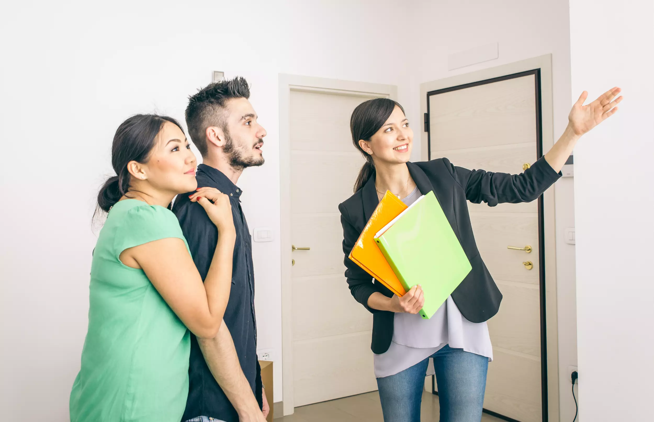 A realtor showing a young couple a new home